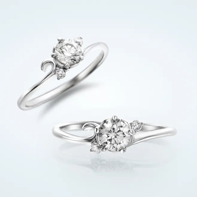 花びらデザインのリング枠に、センターの 0.3ct 天然ダイヤモンドを 5本爪で留めたエンゲージリングです。センターに寄りそうように、両サイドへメレダイヤモンド 2石（計0.03ct）を添えています。</p>             <p>緩やかなV字ラインは、指先がスラリと見えるフォルムです。